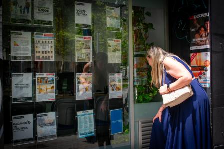 Foto PAULA SAMA 20/06/2024. Mujer mirando anuncios de viviendas a la venta en una inmobiliaria en Glorias, Barcelona.