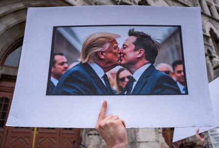 A protester holds a sign with an AI image depicting President Donald Trump and tech billionaire Elon Musk during a 50501 Movement protest against Project 2025 and the executive orders of U.S. President Donald Trump, on Broadway in Nashville, Tennessee, U.S., February 5, 2025. REUTERS/Seth Herald