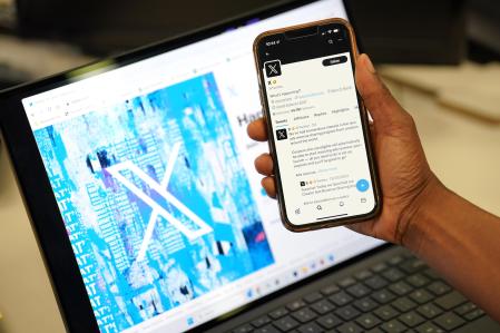 Una persona con un móvil con el logo de la red social X, anteriormente conocida como Twitter (archivo)