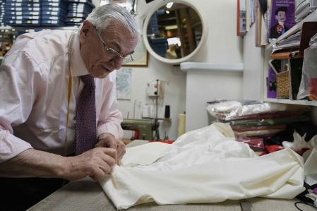 El sastre italiano Raniero Mancinelli, que por iniciativa propia confecciona trajes para un posible futuro Papa, trabaja en una túnica pontificia en su tienda de Roma.
