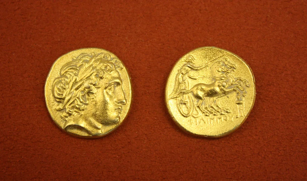 En la fotografía hay dos monedas de macedonia; en un lado de muestra un rostro, en el otro, dos caballos y su jinete.