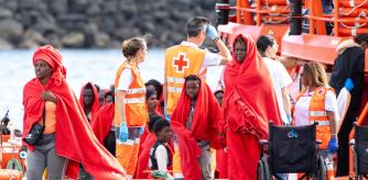 Agentes de los equipos de emergencia atienden a los migrantes en el muelle de Arrecife, a 6 de enero de 2025, en Lanzarote, Canarias (España). Una patera con 60 migrantes a bordo ha sido rescatada en la mañana de este lunes, 6 de enero, en aguas cercanas a la isla de Lanzarote. Una mujer y su bebé, que nació durante la travesía y se encontraba en aparente buen estado de salud, aunque han sido evacuados en helicóptero al hospital insular para hacerles seguimiento.
