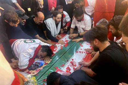 TOPSHOT - This handout picture provided by the Iranian Red Crescent on June 19, 2025 shows mourners during the funeral of two Iranian Red Crescent members who were killed the previous days during an Israeli strike in Tehran. The Iranian Red Crescent said on June 18 that an Israeli attack took place near its building in Tehran, on the sixth day of an air war between Iran and Israel, noting that the strike appeared to not be targeting the aid group. (Photo by Iranian Red Crescent / AFP) / === RESTRICTED TO EDITORIAL USE - MANDATORY CREDIT