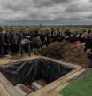 Relatives, friends, and other attendees toss handfuls of soil over the coffins of seventeen-year-old Roman Martyniuk, his eleven-year-old sister Tamara Martyniuk, and eight-year-old brother Stanislav Martyniuk, who were killed by a Russian missile strike, during a funeral ceremony at a cemetery in Korostyshiv, Zhytomyr region, on May 28, 2025, amid the Russian invasion of Ukraine. On the night of May 24 to May 25, at least 13 Ukrainian civilians were killed in massive Russian strikes, including three of the five Martyniuk children, who were killed by a cruise missile in the Ukrainian town of Korostyshiv, about 100 kilometers from Kyiv. The Russian invasion has left tens of thousands dead in Ukraine, including military personnel and civilians. At least 630 children have been killed, according to the latest official figures. (Photo by Roman PILIPEY / AFP)