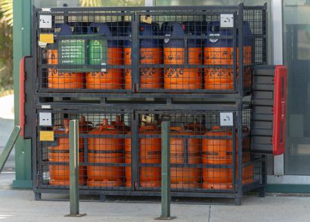 Bombonas de butano en una gasolinera, a 16 de julio de 2024, en Madrid (España). El precio máximo de venta al público de la bombona de butano bajará un 5% a partir de hoy, hasta los 15,34 euros, con lo que encadenará su segunda revisión a la baja, según una resolución publicada en el Boletín Oficial del Estado (BOE). En concreto, la reducción de esta última revisión se debe a la caída en la cotización de las materias primas (-8,8%), la leve depreciación del euro frente al dólar (-0,1%) en los dos últimos meses y el aumento del coste de los fletes (+14,1%), informaron en fuentes del Ministerio para la Transición Ecológica y el Reto Demográfico.
