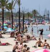 Tourists gather on Palma's Beach in Palma de Mallorca on July 18, 2025. Spanish company Amadeus, the world#{emoji}146;s leading travel booking provider, saw its profits jump by 12% in the first half of the year, driven by the strength of the tourism and air transport sectors, which boosted its revenues, according to its results published on July 31, 2025. (Photo by JAIME REINA / AFP)