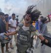 A protester wearing flak jacket and carrying a shield snatched from a policeman shouts slogans at the Singha Durbar, the seat of Nepal's government's various ministries and offices during a protest against social media ban and corruption in Kathmandu, Nepal, Tuesday, Sept. 9, 2025. (AP Photo/Niranjan Shrestha)