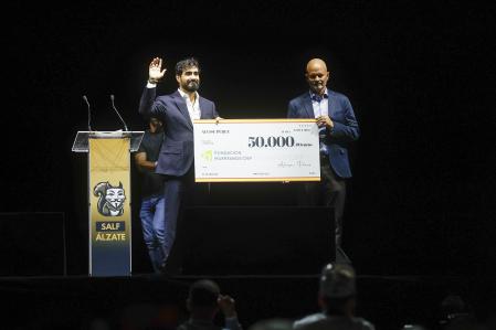 El líder de la formación, Alvise Pérez (i) entrega un cheque en la presentación oficial del 