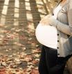 Close up of pregnant woman outdoors. Copy space.