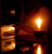 Un jubilado escucha la radio a la luz de las velas, al haberse quedado sin luz por un apagón eléctrico