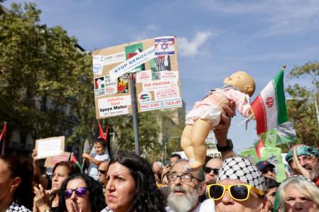Participantes en la manifestación exhiben pancartas en contra del