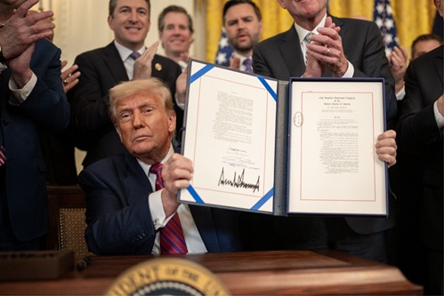 Trump muestra la firma de la Ley GENIUS.