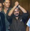 FILE - Marwan Barghouti, center, raises his handcuffed hands in the air on the opening day of his trial in Tel Aviv, Israel, Aug. 14, 2002. (AP Photo/Brennan Linsley, File)