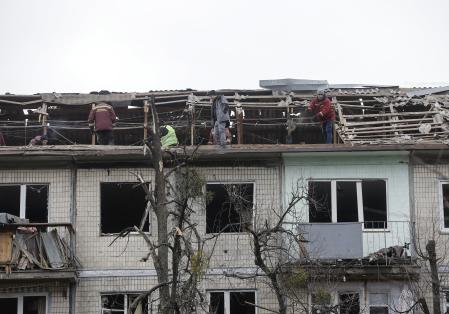 KYIV (Ukraine), 23/12/2025.- Ukrainian communal workers clean debris at the site of a Russian drone strike on a five-story residential building in Kyiv, Ukraine, 23 December 2025, amid the Russian invasion. At least five people were injured in Kyiv, including one child, as a result of the overnight combined Russian attacks on Ukraine using more than 650 shock drones and 38 missiles of different types, according to the State Emergency Service of Ukraine. (Rusia, Ucrania, Kiev) EFE/EPA/SERGEY DOLZHENKO