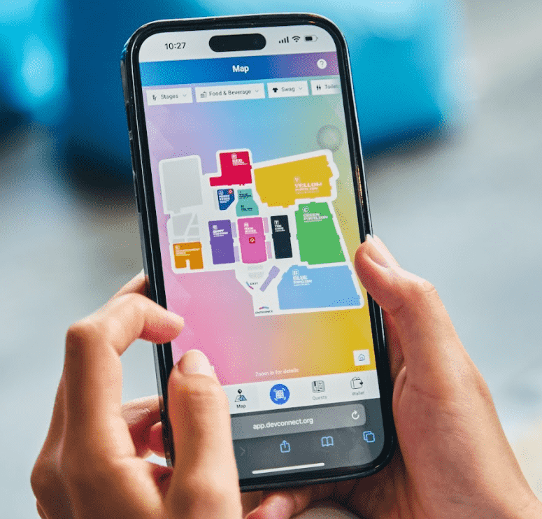 En la pantalla de un teléfono se observa una imagen con los diferentes escenararios de la Devconnect Argentina 2025. gracias a la app del evento.
