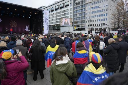 Oslo (Norway), 10/12/2025.- People watch the awarding ceremony of the Nobel Peace Prize broadcasted on a big screen at City Hall Square (Radhusplassen) in Oslo, Norway, 10 December 2025. Venezuelan opposition leader Maria Corina Machado was awarded the Nobel Peace Prize 2025 for her tireless work to secure democratic rights for the people of Venezuela, and for her fight for a just and peaceful transition from dictatorship to popular rule. Due to the circumstances in her home country of Venezuela, the Nobel Peace Prize laureate was unable to attend the award ceremony in Norway. (Noruega) EFE/EPA/GORM KALLESTAD NORWAY OUT