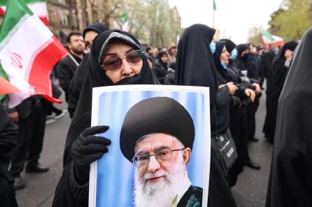 Una mujer sostiene una imagen de Jamenei en el funeral en Teherán por las víctimas mortales entre las fuerzas de seguridad&nbsp;