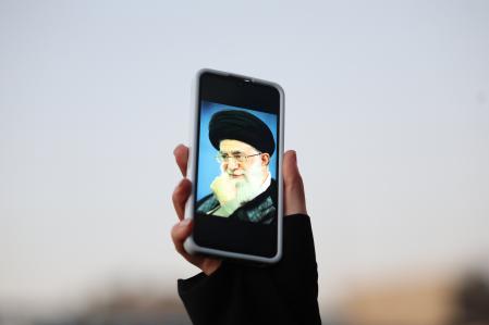 Una persona sostiene en Teherán una foto en su teléfono del líder supremo iraní Jamenei, asesinado en el ataque de EE.UU. e Israel ,