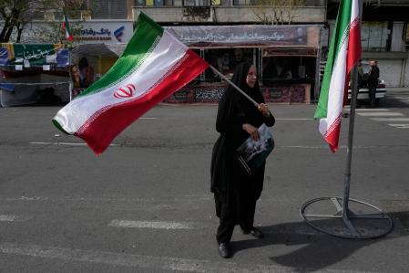 Una mujer ondea una bandera iraní en apoyo al Gobierno del país en el centro de Teherán, Irán