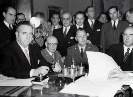 La firma de los Pactos de Madrid por parte del ministro de Asuntos Exteriores, Alberto Martín-Artajo; el ministro de Comercio, Manuel Arburúa (a la izquierda y a la derecha en primer término), y el embajador de Estados Unidos (fuera de la imagen)