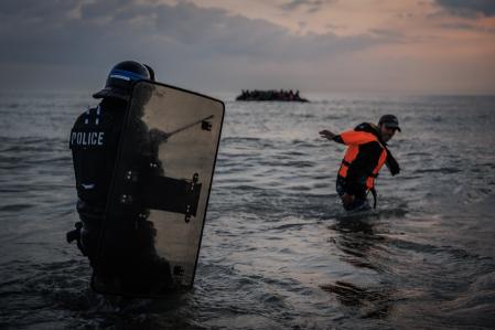 Un policía francés entra en el agua para tratar de detener a un migrante.