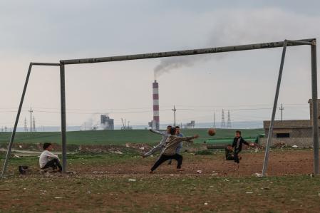 La refinería de petróleo de Erbil, en el norte de Irak, al fondo de un improvisado campo de fútbol