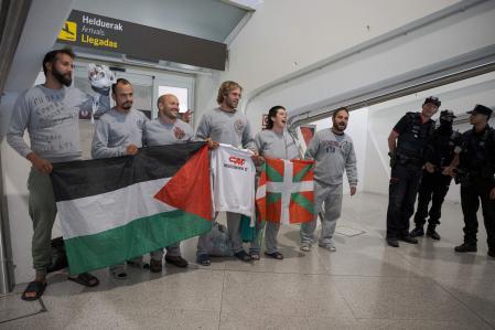 Miembros de la delegación vasca de la Flotilla Global Sumud posan con una bandera vasca y una bandera palestina a su llegada al aeropuerto de Bilbao&nbsp;