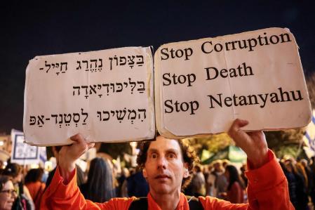 Un manifestante israelí porta carteles con las frases: “Basta de corrupción, muerte y Netanyahu”&nbsp;