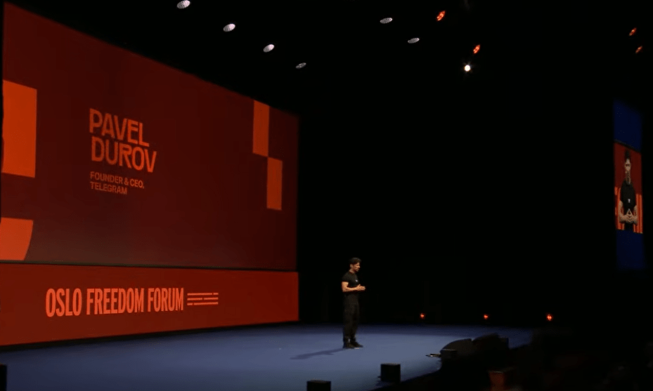 Pavel Durov de pie frente al micrófono en el escenario principal del Oslo Freedom Forum, vistiendo de negro y hablando ante el público sobre la privacidad y las regulaciones de vigilancia estatal.