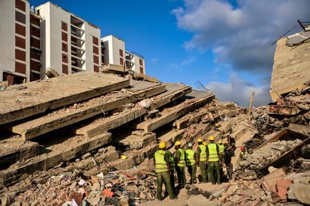 Trabajadores entre ruinas de edificios colapsados en La Guaira