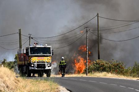 Un bombero camina por una carretera junto a un incendio forestal cerca de Ille-sur-Têt, en el sur de Francia&nbsp;