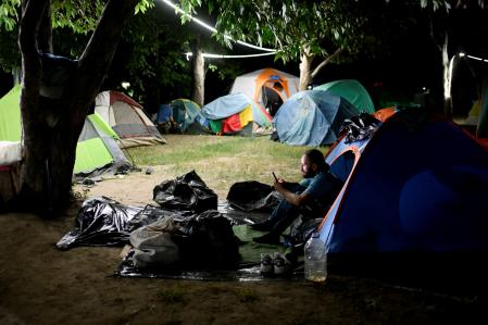 Personas que se han quedado sin hogar duermen en tiendas de campaña, en Caracas
