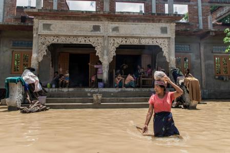 Una mujer camina por una zona inundada debido a las lluvias monzónicas y la crecida del río en Wetlet, región de Sagaing, Myanmar 