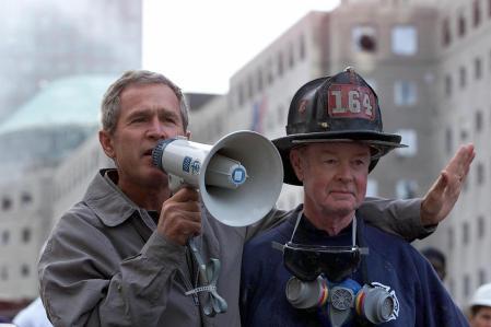 El presidente de Estados Unidos, George W. Bush, junto al bombero jubilado Bob Beckwith, de 69 años, habla con voluntarios y bomberos mientras inspecciona los daños en el lugar&nbsp;