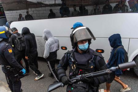 La policía española escolta a los migrantes en autobuses tras recoger a quienes dormían a la intemperie frente a los almacenes de Tarajal, en las afueras de Ceuta&nbsp;