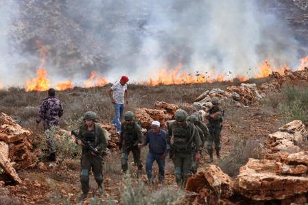 Soldados israelíes abandonan el lugra dejando atrás un incendio tras disparar gases lacrimógenos sobre los campos palestino, al sur de Nablús, el 3 de octubre. Imagen captada por Ashtiyé&nbsp;