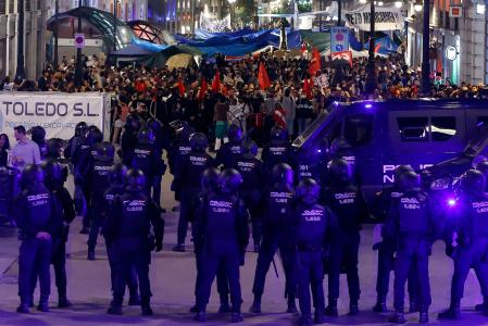 Agentes de policía montan guardia en una de las calles que conducen a la Puerta del Sol, en Madrid (al fondo), para separar a los concentrados de grupos de extrema derecha, el día 3&nbsp;