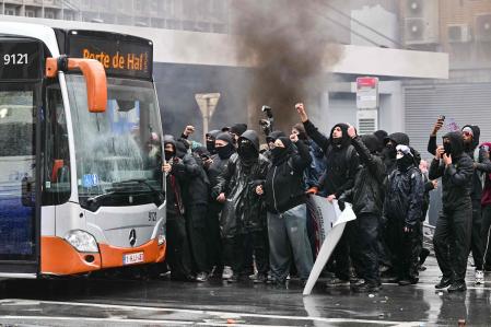 Manifestantes se resguardan tras un autobús durante una protesta contra las medidas presupuestarias del Gobierno federal en Bruselas, el día 9&nbsp;